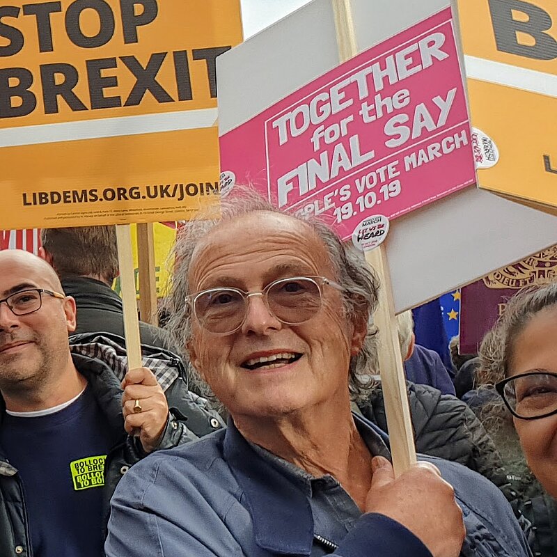 Photo of Roger Kutchinsky, Treasurer for the Hertsmere Lib Dems, carrying a banner with a group of people at an anti-Brexit march. The banner reads "Together for the final say"